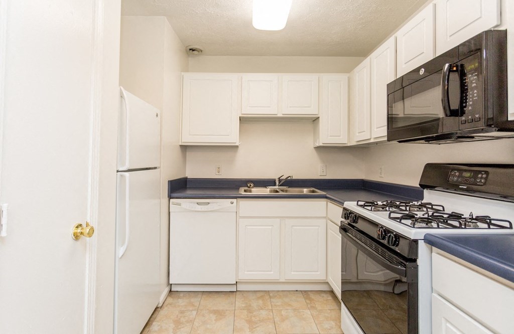 a kitchen with white cabinets and a stove and a refrigerator