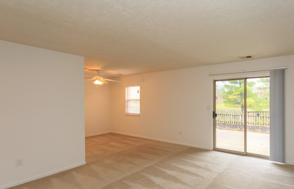 the living room of an empty house with a patio door