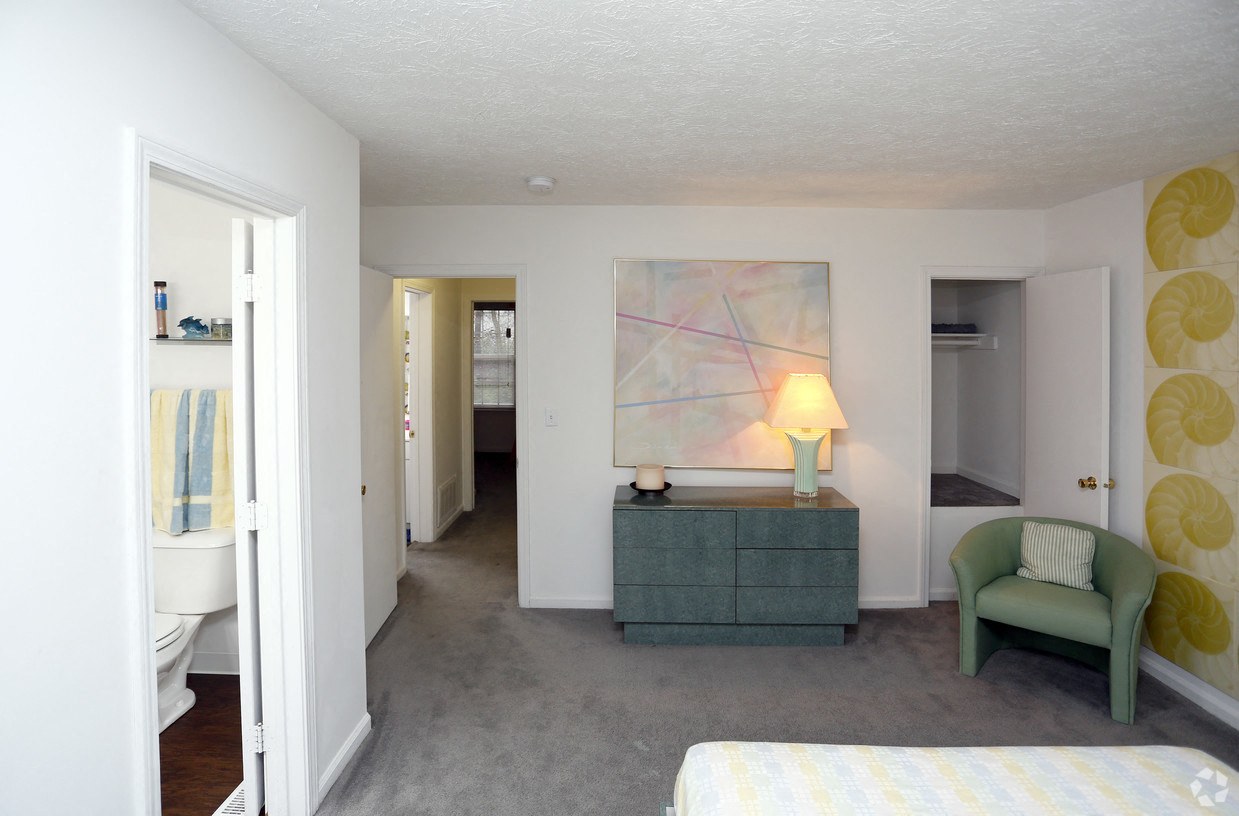 a bedroom with a bed and a dresser and a chair in a room with