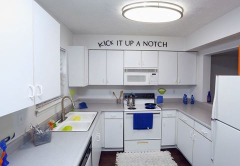 a kitchen with white cabinets and a sink  it up a notch