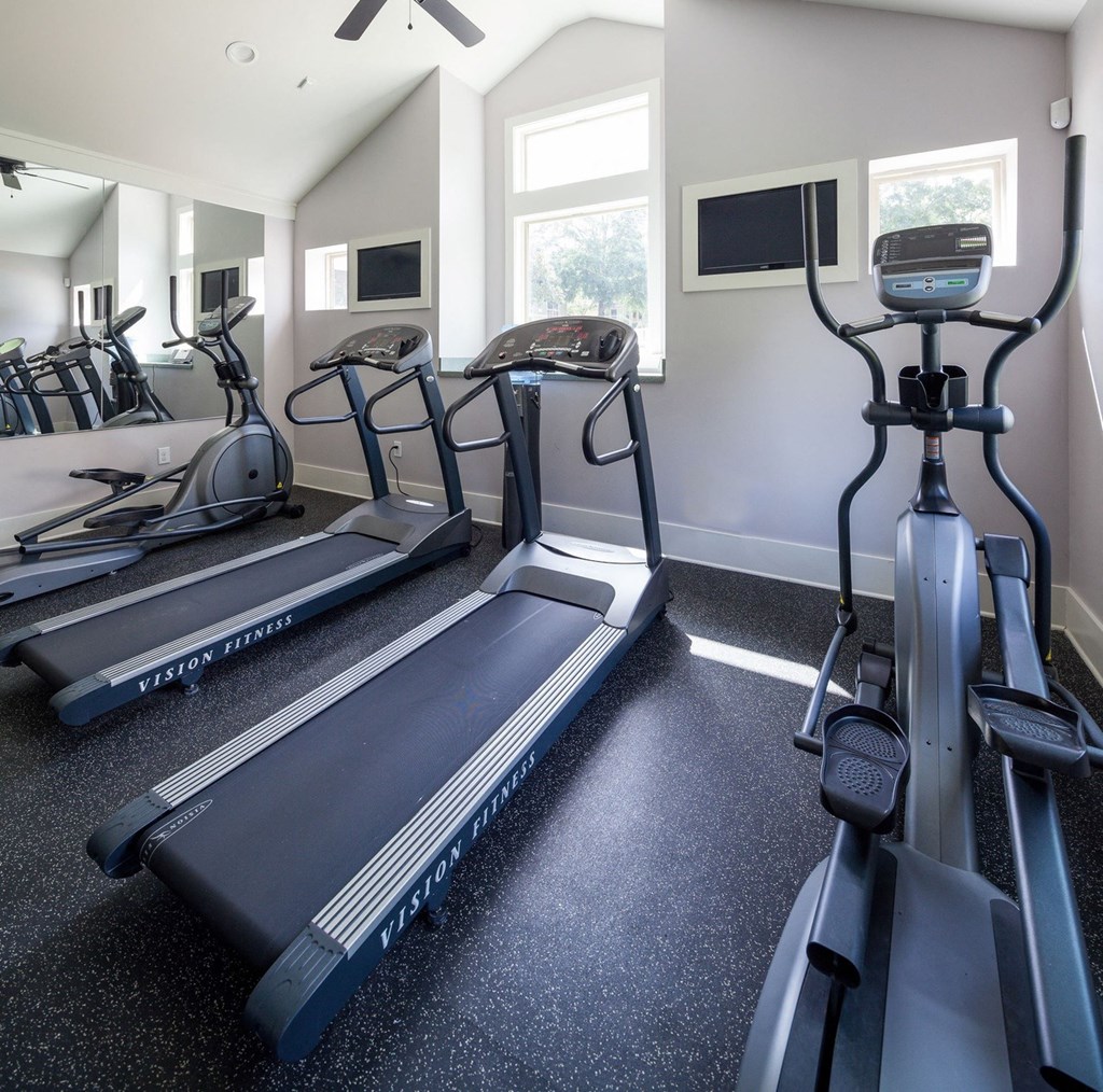a gym with several treadmills and other exercise equipment
