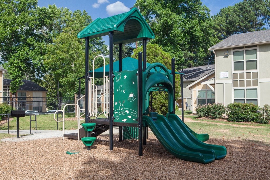 a playground with a slide and swing set in a park