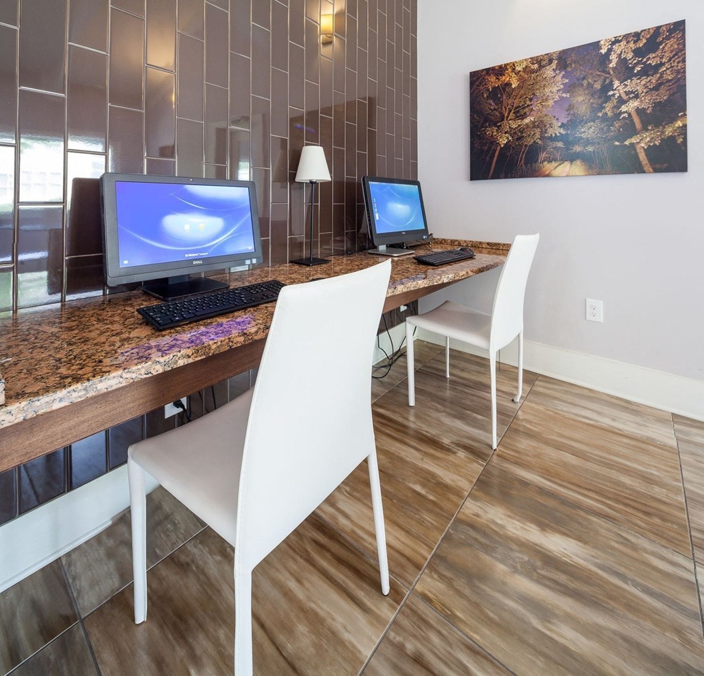 a desk with two computers and a laptop on it