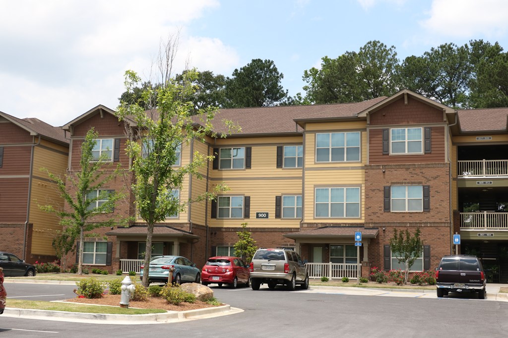 decatur affordable family apartment  an apartment building with cars parked in front of it