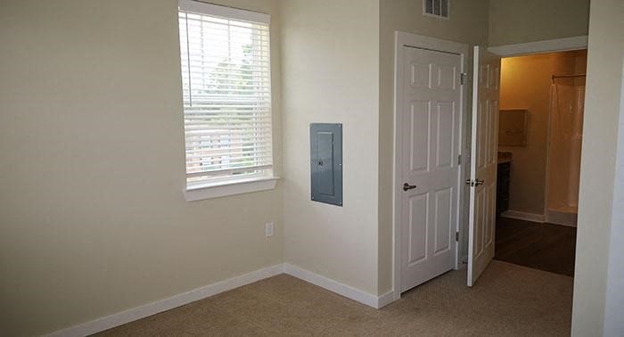 an empty room with a white door and a window