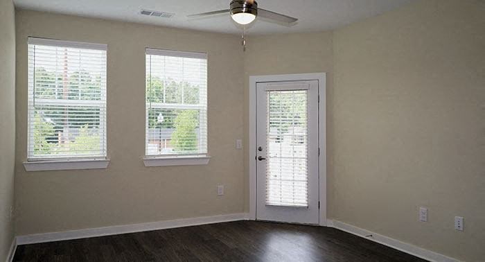 a living room with a door and three windows