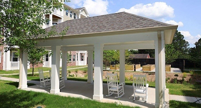 a covered patio with rocking chairs under a pavilion