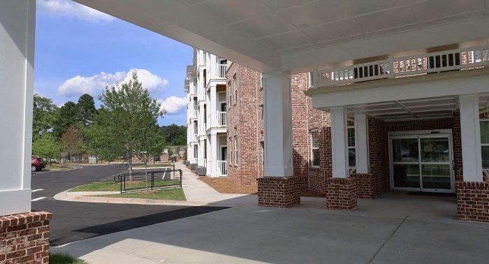 a brick building with a porch and a park