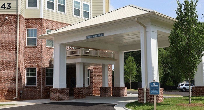 a building with a porch and a sign on the side of it