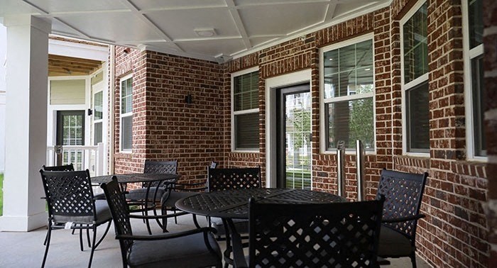 a patio with tables and chairs outside of a brick house