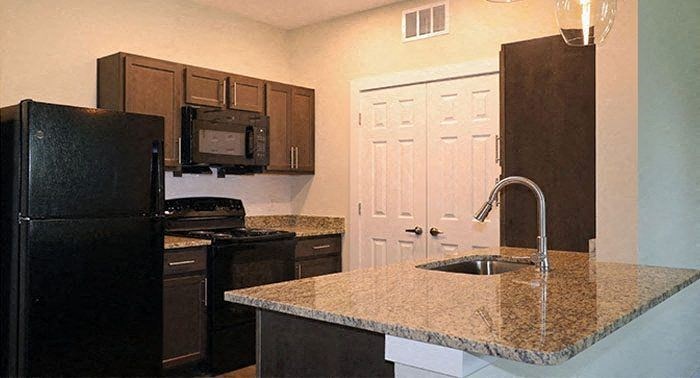 a kitchen with a granite counter top and a black refrigerator