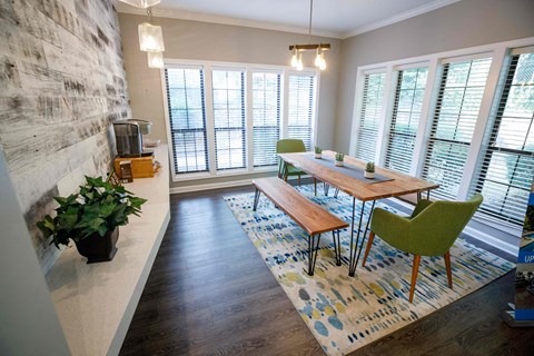 a dining room with a wooden table and green chairs