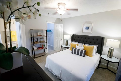 a bedroom with a large white bed and a ceiling fan decatur luxury living