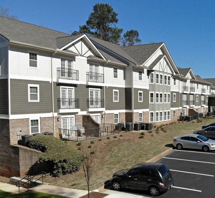 a large apartment building with cars parked in a parking lot