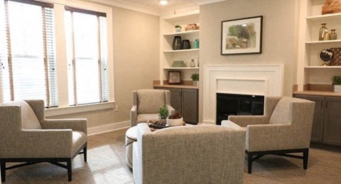a living room with chairs and a fireplace