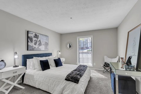 A bedroom with a white bed and a blue headboard.