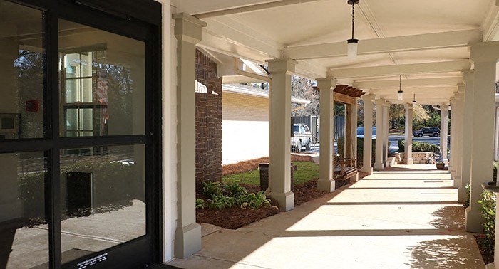 a sidewalk in front of a building with glass doors