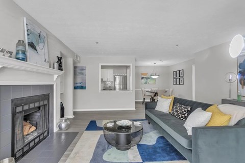 A modern living room with a fireplace and a grey couch.