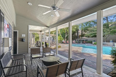 A patio with a table and chairs overlooking a pool.