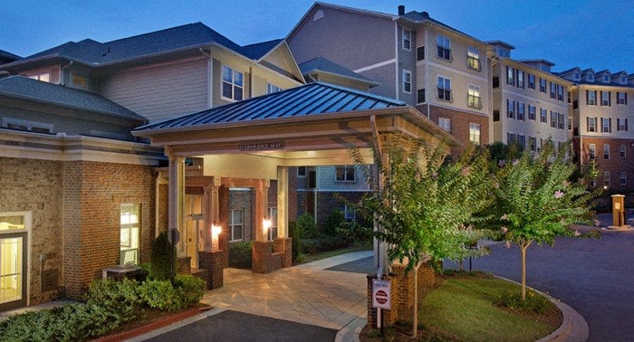 A building with a lit entrance and a sign on the ground.