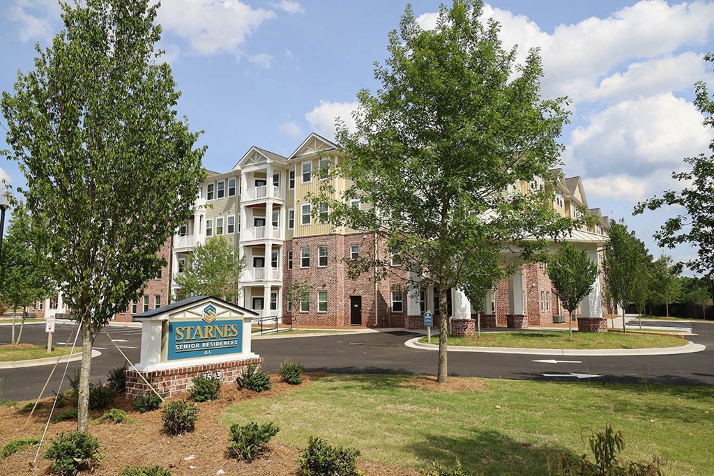 an apartment building with a sign in front of it