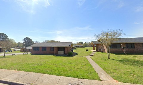 the front yard of a house with a sidewalk and grass