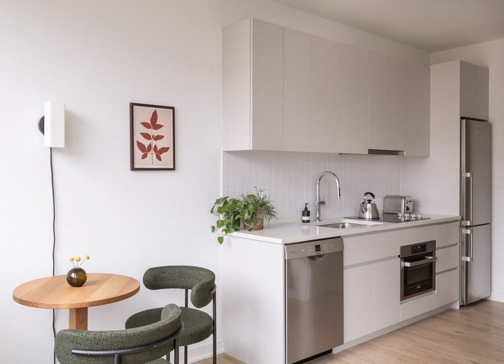 a kitchen with a small table and chairs and a refrigerator