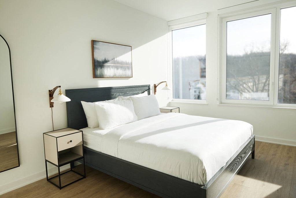 a bedroom with a large bed and three windows