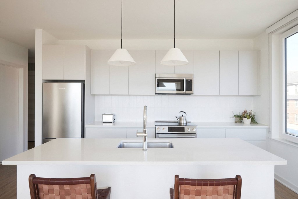 a kitchen with white cabinets and a white counter top