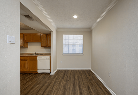 A kitchen with wooden cabinets and a white dishwasher.