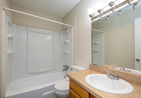 A white bathroom with a toilet, sink, and bathtub.