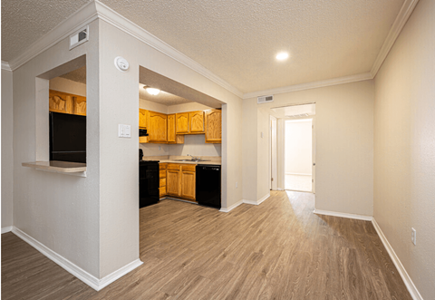 A kitchen with wooden cabinets and a black fridge.