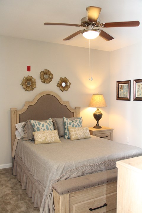 a bedroom with a bed and a ceiling fan