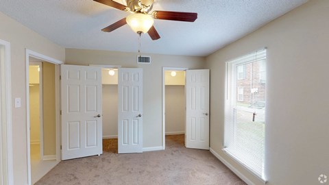 a living room with three doors and a ceiling fan
