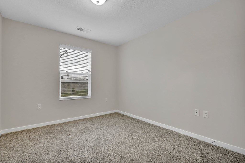 A room with a window and a picture on the wall.