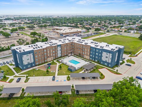 A large apartment complex with a swimming pool in the center.