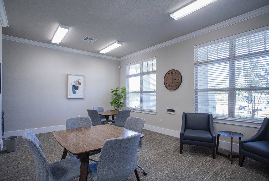 a room with a table and chairs and a clock on the wall