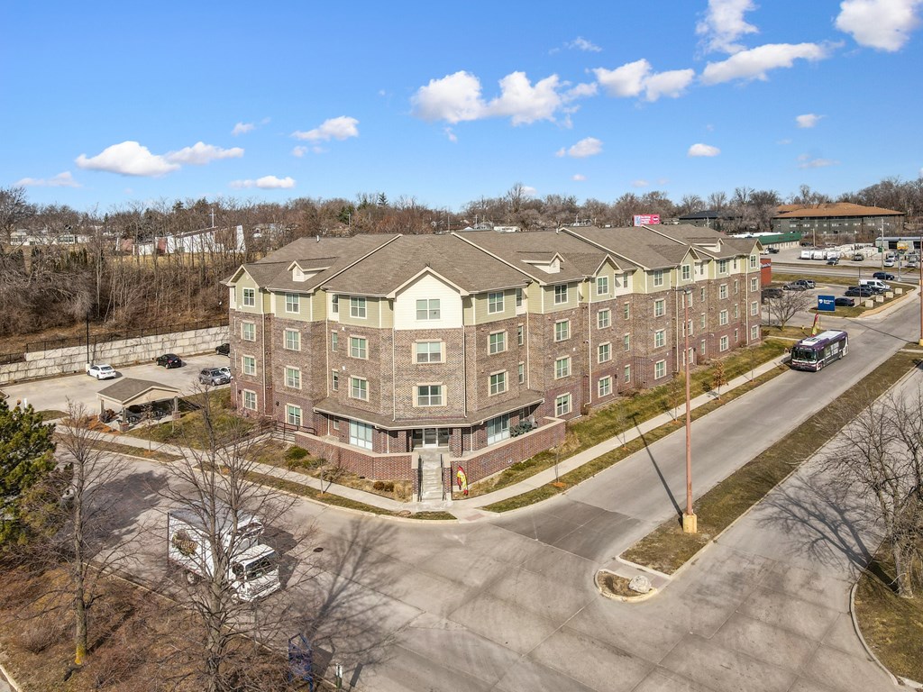 A large apartment complex with a parking lot in front.
