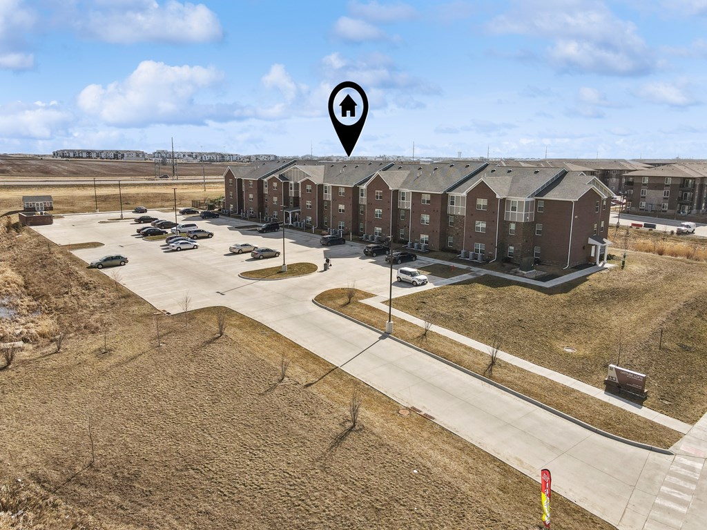 A bird's eye view of a parking lot with a building in the background.