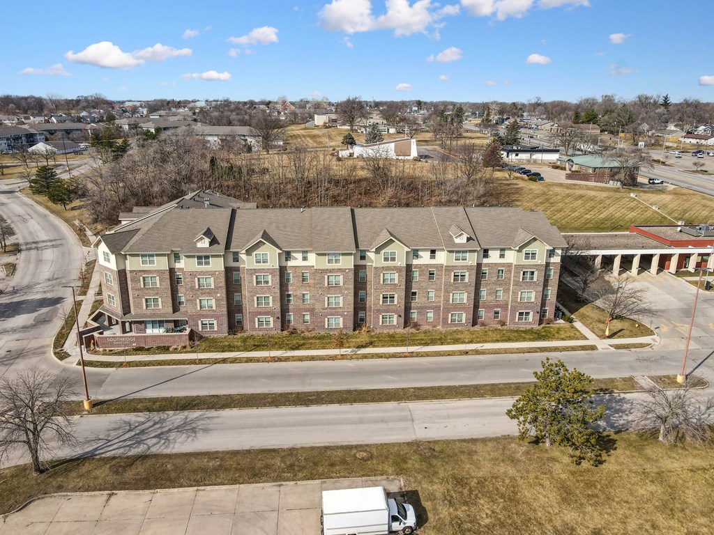 A white van is parked on a road in front of a building.