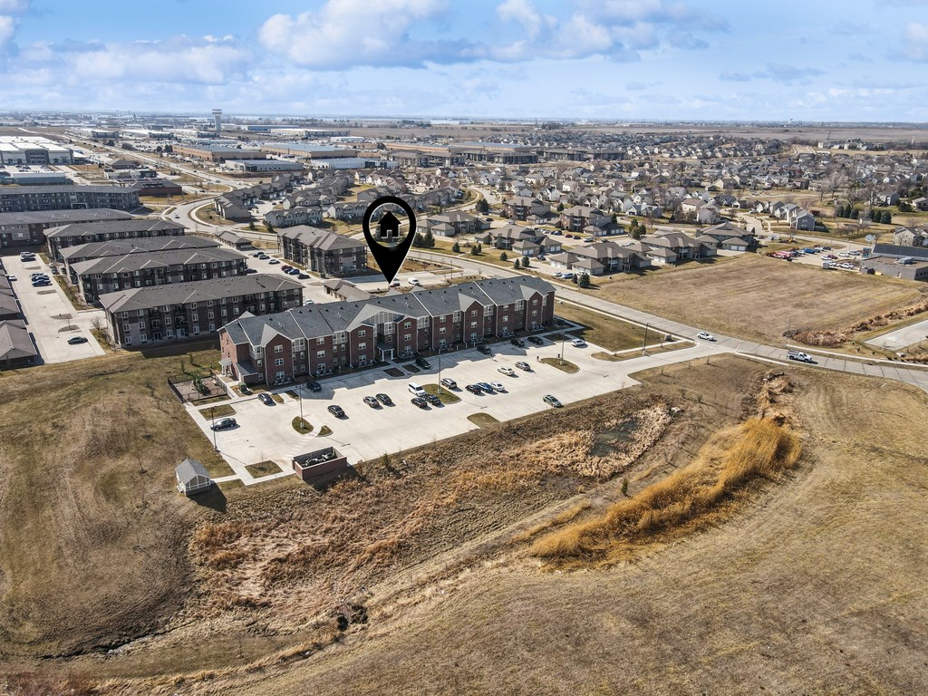 A bird's eye view of a town with a large building in the foreground and a residential area in the background.