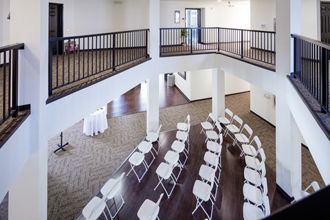 A room with a balcony and a long table with chairs.