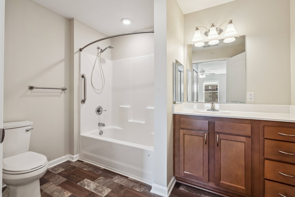 A white bathroom with a toilet, sink, and shower.