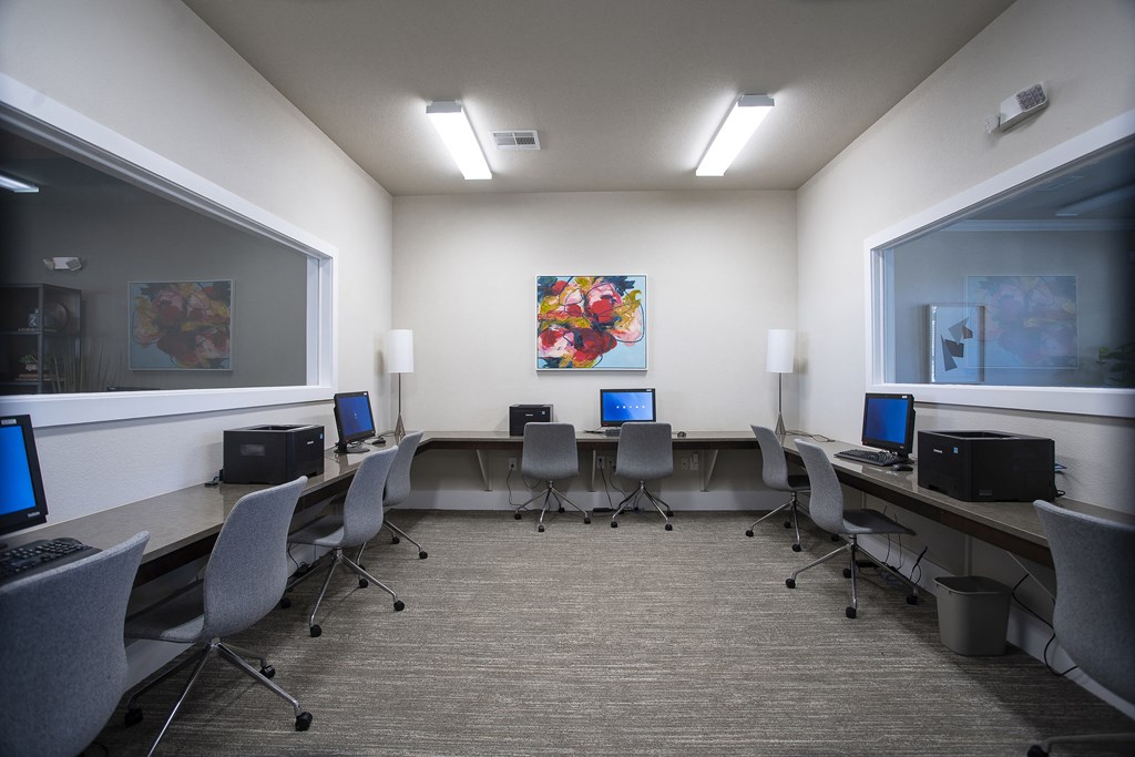 a conference room with desks and chairs and computers