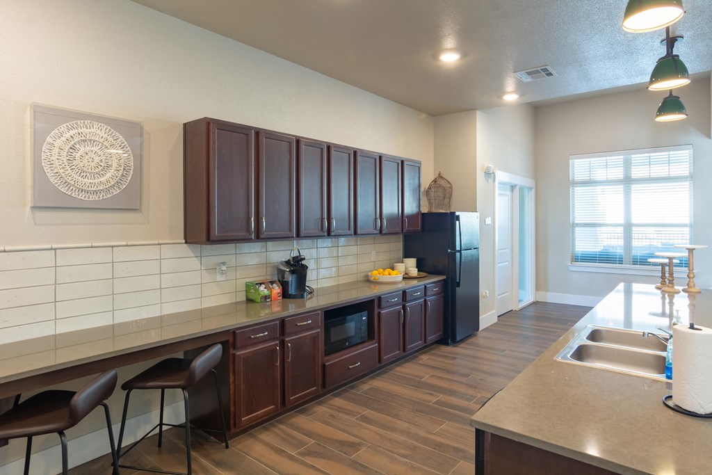 a kitchen with wooden cabinets and a counter with a sink and a refrigerator