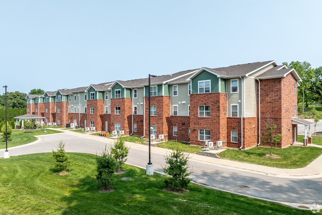 A long building with a green roof and red brick walls.