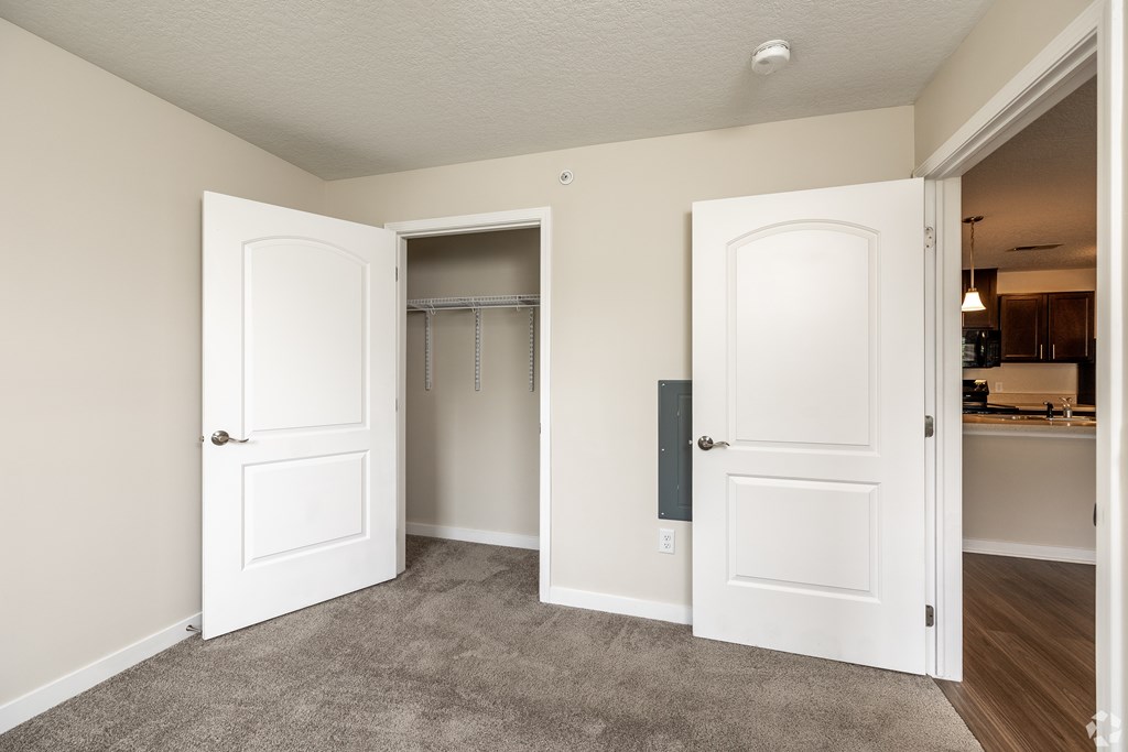 A room with two white doors, one of which is open.