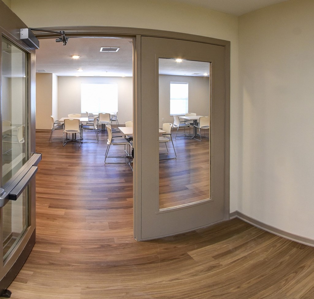 A room with a glass door and a wooden floor.