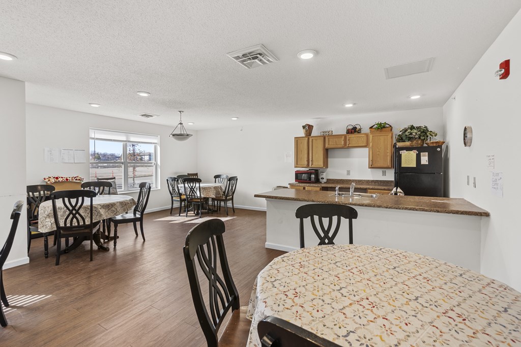 A kitchen and dining room with wooden floors and furniture.