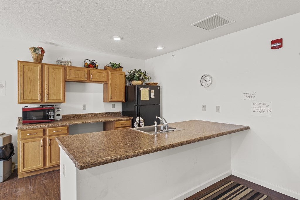 A kitchen with a granite countertop and wooden cabinets.